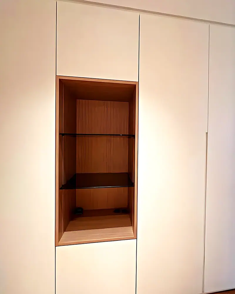 Armario a medida con nicho de madera iluminado y baldas de vidrio