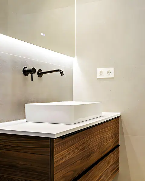 Lavabo rectangular sobre mueble de nogal con grifería negra empotrada